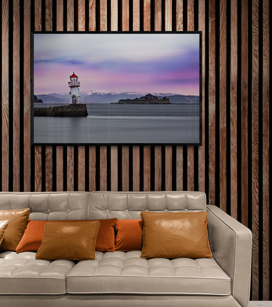 Veggbilde på plakat med ramme, av Munkholmen og ei fyrlykt ved munningen av Nidelva i Trondheim